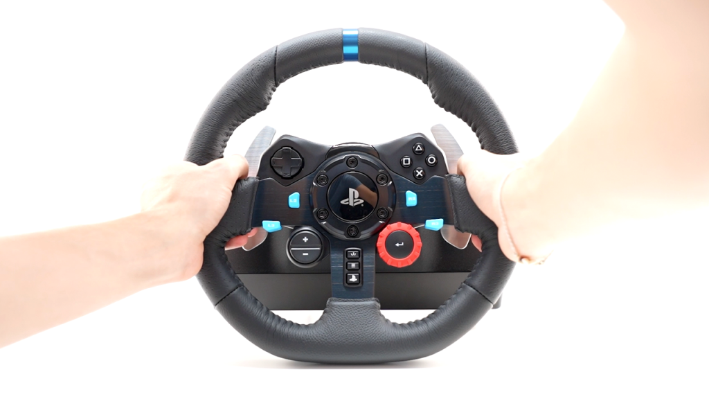 Two hands holding logitech g29 wheel